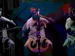 Jeffrey Krieger, electric cello in a still from the video, Garland with music by Robert Carl and video by Victor Velt